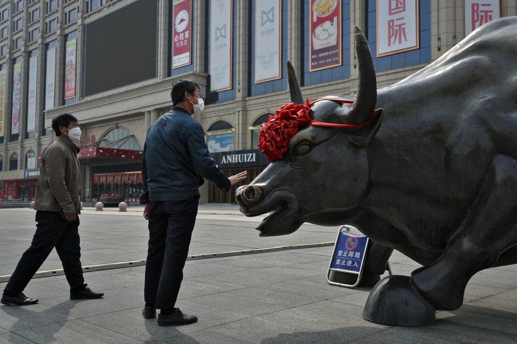 A man touches the bull statue outside a shopping mall in Beijing last year. Photo: AP