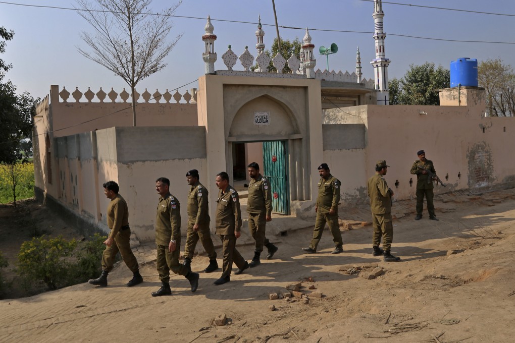 Police guard a mosque where a mob stoned a man for allegedly desecrating the Koran. Photo: AP