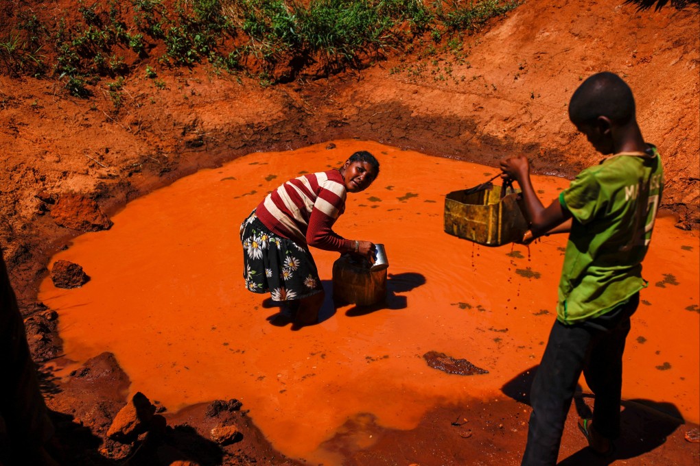 Local residents Masy fill plastic canisters with rain water in Sampona commune, Madagascar on February 11. Photo: Reuters