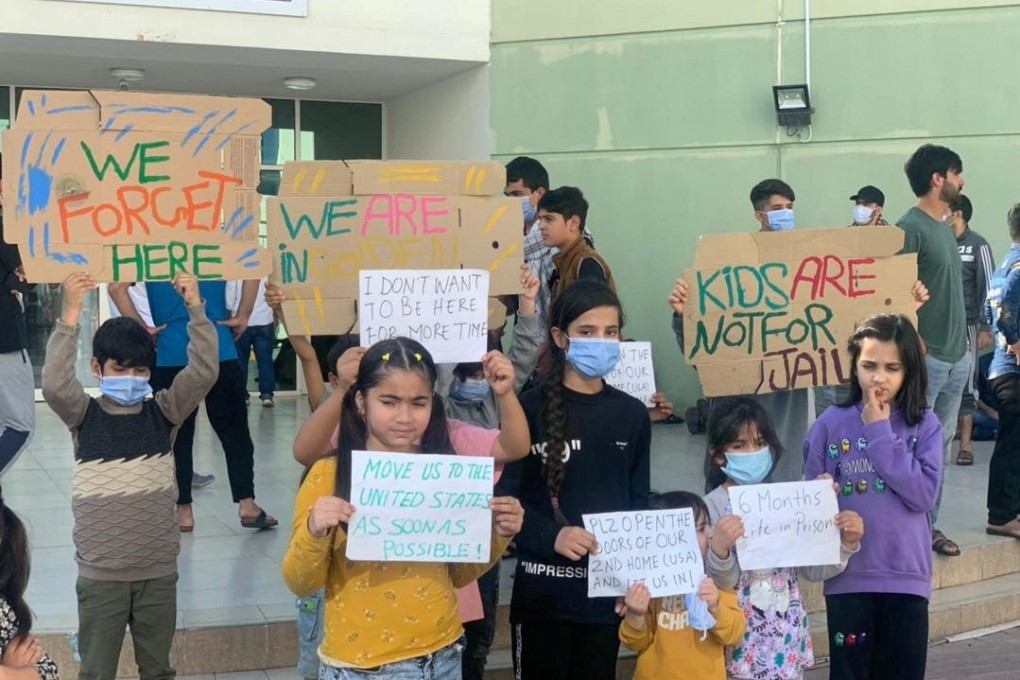Afghan children hold banners during a protest over the US relocation process at a Gulf facility in Abu Dhabi, UAE on February 10. Photo: Rise to Peace / via Reuters