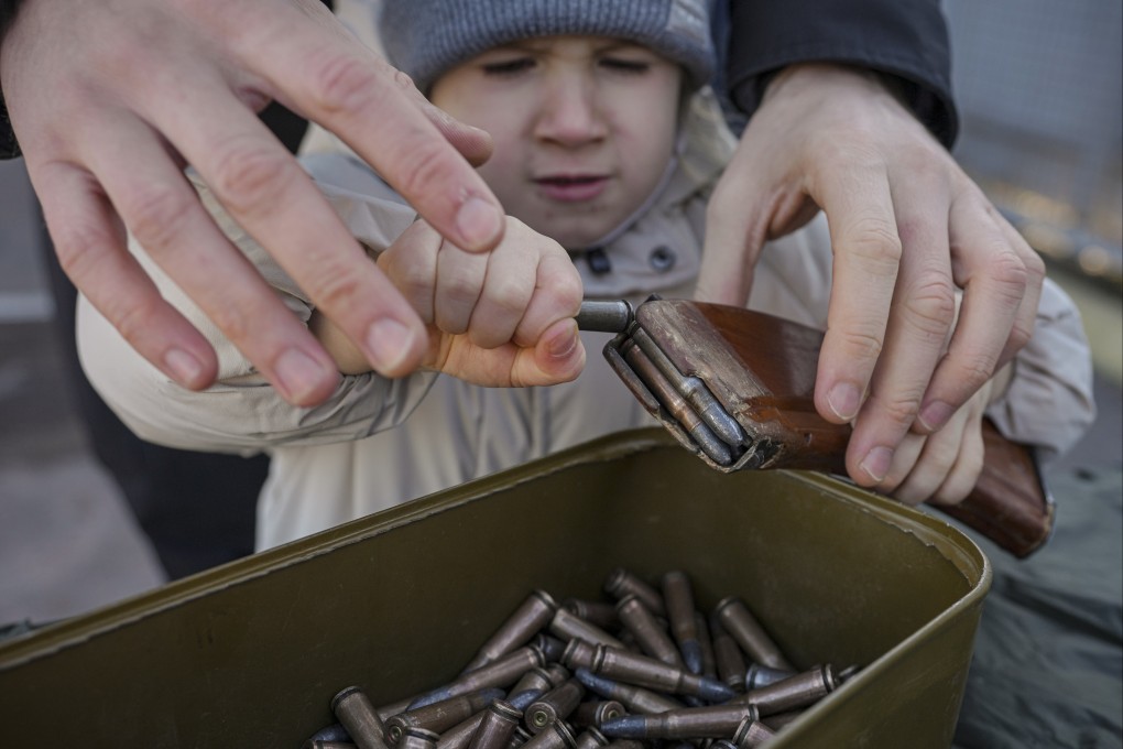 A small child struggles to remove ammunition from a clip during a basic combat training for civilians, organised by the Special Forces Unit Azov, of Ukraine’s National Guard, in Mariupol, Donetsk region, Ukraine on February 13. Photo: AP
