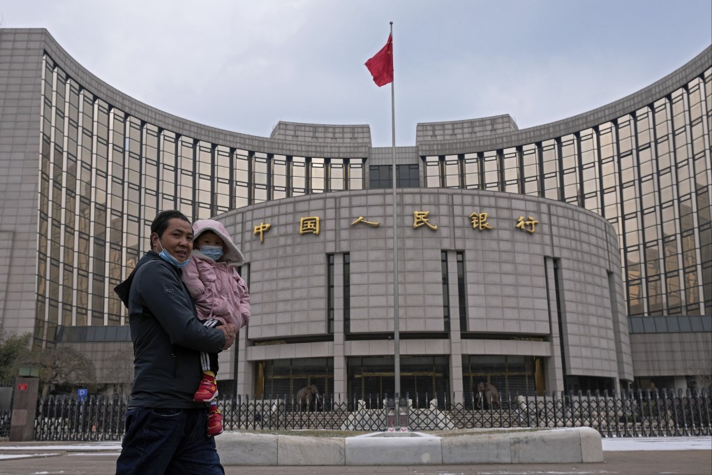 A man carries a child in front of China’s central bank in Beijing on January 20. The cautionary mood in the market makes sense when underlying demand from the private sector remains subdued. Photo: AP