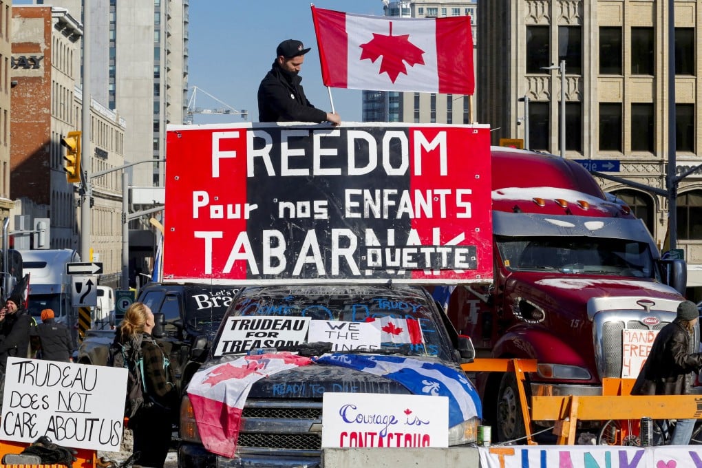 A person attaches a flag to a truck as truckers and their supporters continue to protest coronavirus disease vaccine mandates, in Ottawa, Ontario, Canada, February 7, 2022. Photo: Reuters