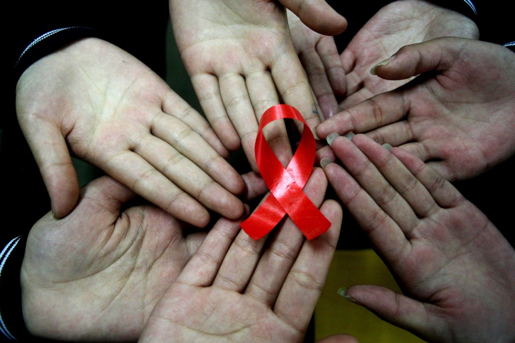 Students show a handmade red ribbon for World Aids Day at a school in Hanshan in China’s Anhui province in November 2009. Photo: AFP
