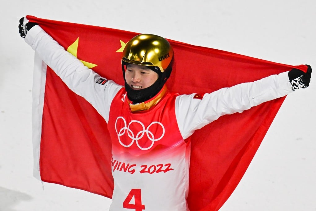 Qi Guangpu celebrates with the China flag after winning the men’s freeski aerials. Photo: Xinhua