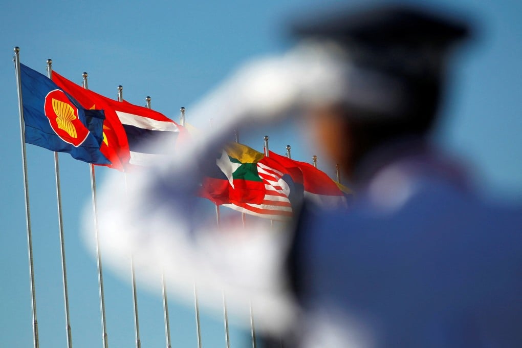 A police officer stands near national flags of Asean countries. Photo: Reuters