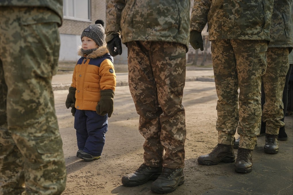 A child copies the position of Ukrainian servicemen standing at attention during a Day of Unity event in Sievierodonetsk, the Luhansk region, eastern Ukraine on Wednesday. Photo: AP