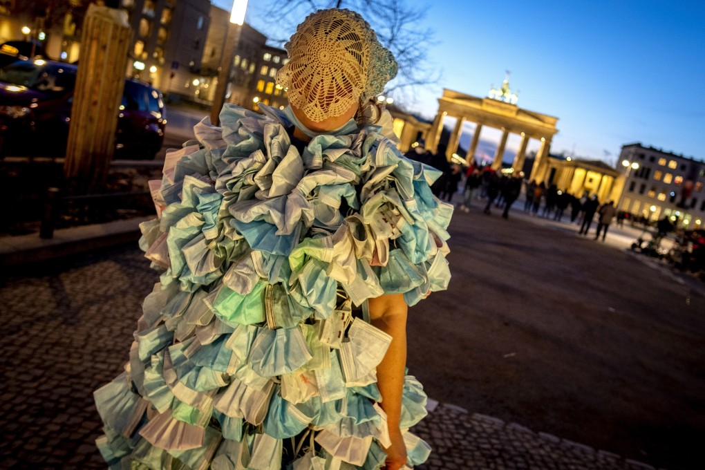 A woman wears a dress made of hundreds of face masks as she returns from a demonstration in Berlin on Saturday. Photo: AP