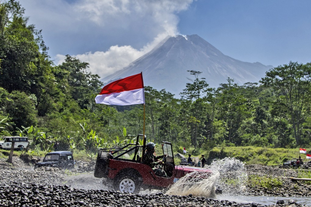 The Indonesian national flag waves from a car with Mount Merapi as the backdrop. Photo: AP
