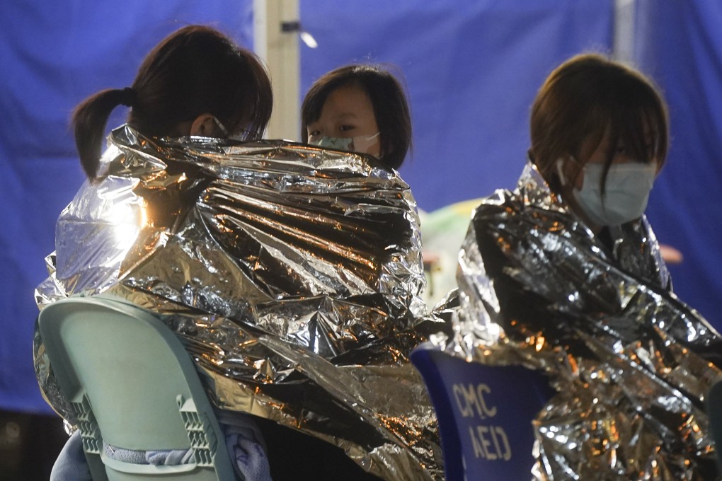 Patients wrapped in thermal blankets wait at a temporary holding area outside Caritas Medical Centre in Cheung Sha Wan on Wednesday. Photo: Sam Tsang