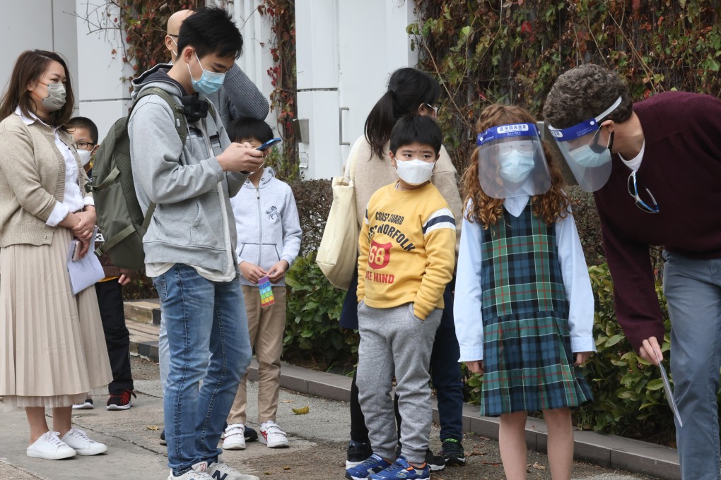 Parents and their children queue outside a coronavirus vaccination centre. Photo: K. Y. Cheng