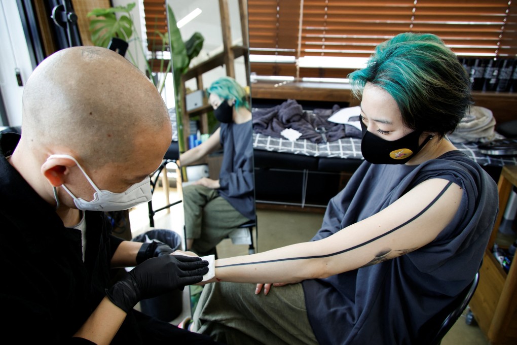 Tattooist Kim Do-yoon attends to a customer in his tattoo studio in Seoul. Photo: Reuters