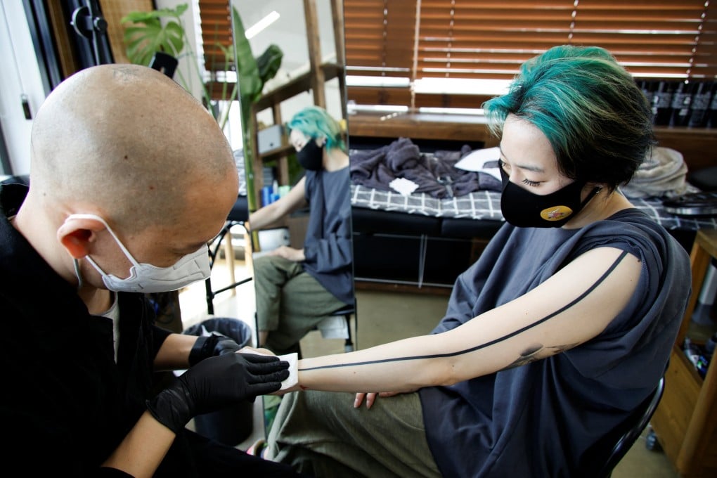 Tattooist Kim Do-yoon attends to a customer in his tattoo studio in Seoul. Photo: Reuters