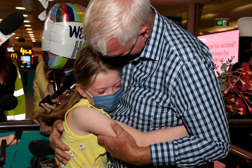 A man hugs his granddaughter at Sydney International Airport on February 21, 2022. Photo: AFP
