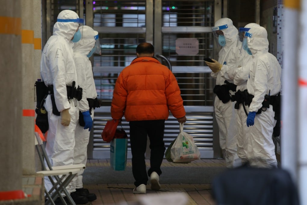 Police officers stand guard outside a residential building placed under lockdown in Kwai Chung Estate, on January 25. Photo: Yik Yeung-man
