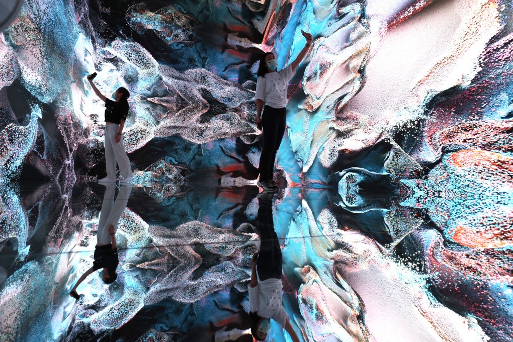 Staff at the inaugural Digital Art Fair Asia in Hong Kong’s Central district take photos of a piece from artist Refik Anadol’s NFT Collection, on September 30, 2021. The fair showcased a number of works that were later converted into digital NFTs and auctioned online. Photo: May Tse