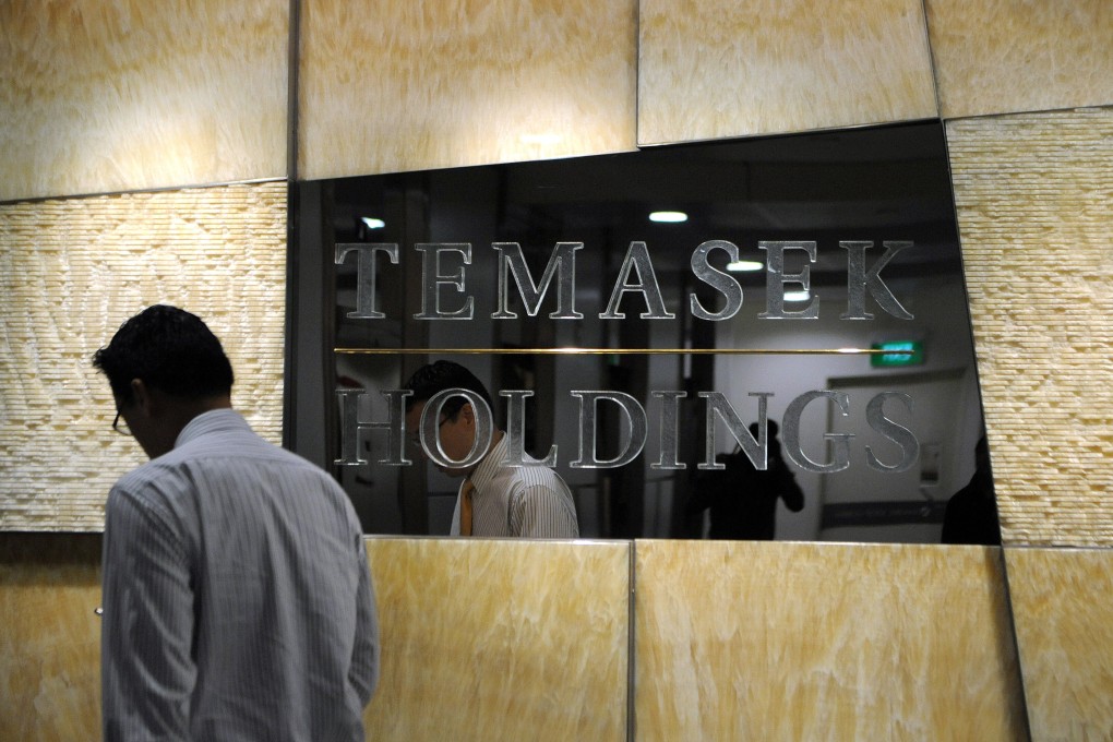A man walks past a company logo for Temasek Holdings in Singapore. File photo: AFP
