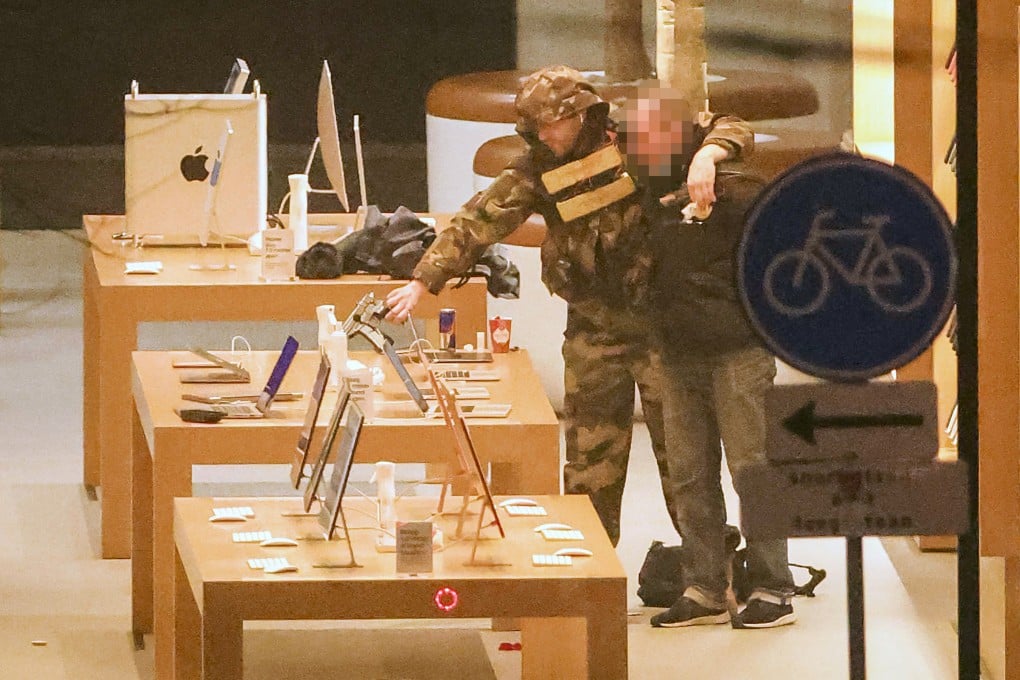 The hostage-taker (left) puts his arm over the shoulder of the hostage in the Apple store in Amsterdam. Photo: EPA
