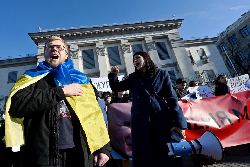 An activist wrapped in Ukrainian flag shout slogans during a rally outside Russian embassy in Kyiv. Photo: AFP