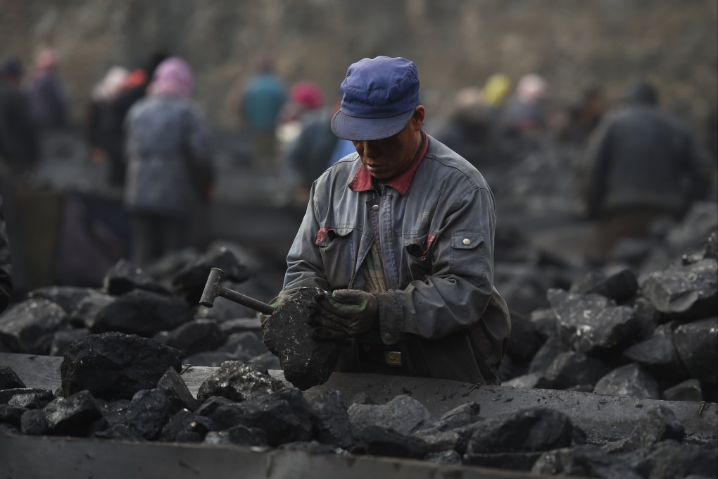 A worker sorting coal on a conveyer belt, near a coal mine at Datong, in northern China’s Shanxi province on November 25, 2015. Photo: AFP