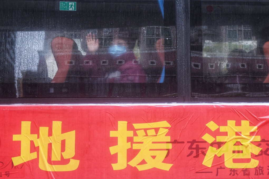 A member of the mainland medical team heading to Hong Kong to support the city’s Covid-19 fight waves from inside a shuttle bus in Guangzhou, as the bus prepares to leave for Hong Kong on February 19. Photo: AFP