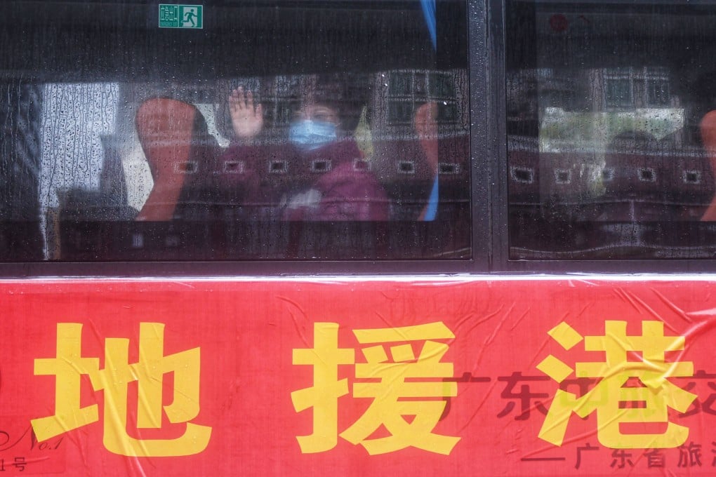 A member of the mainland medical team heading to Hong Kong to support the city’s Covid-19 fight waves from inside a shuttle bus in Guangzhou, as the bus prepares to leave for Hong Kong on February 19. Photo: AFP