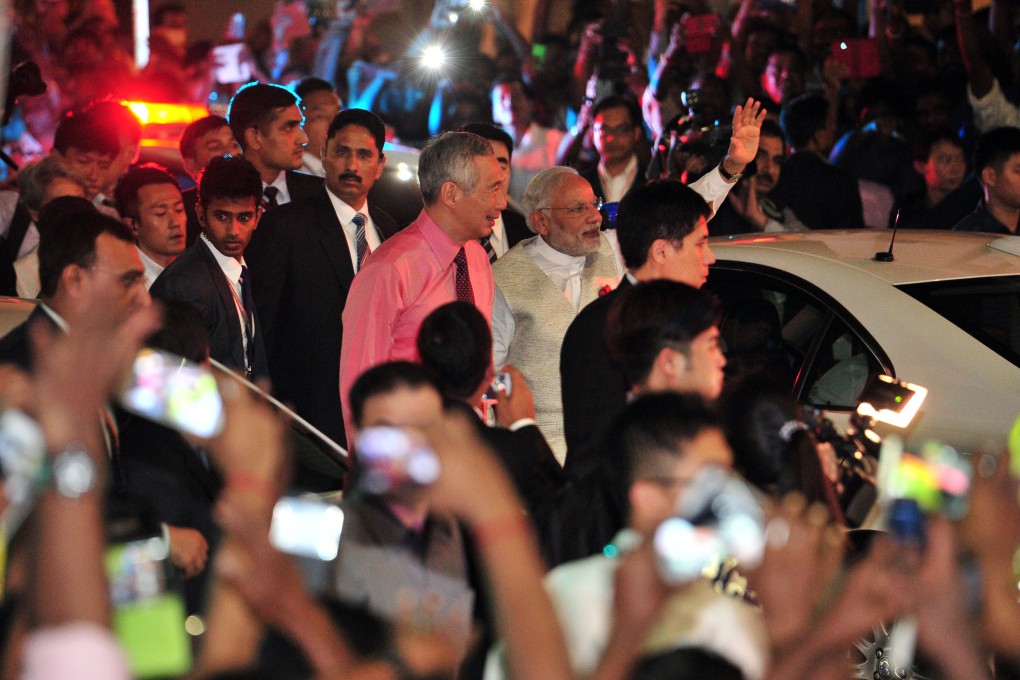 Singapore’s Prime Minister Lee Hsien Loong (left, centre) and India’s Prime Minister Narendra Modi (right, centre) greet crowds at Singapore’s Little India on November 23, 2015. Photo: Xinhua
