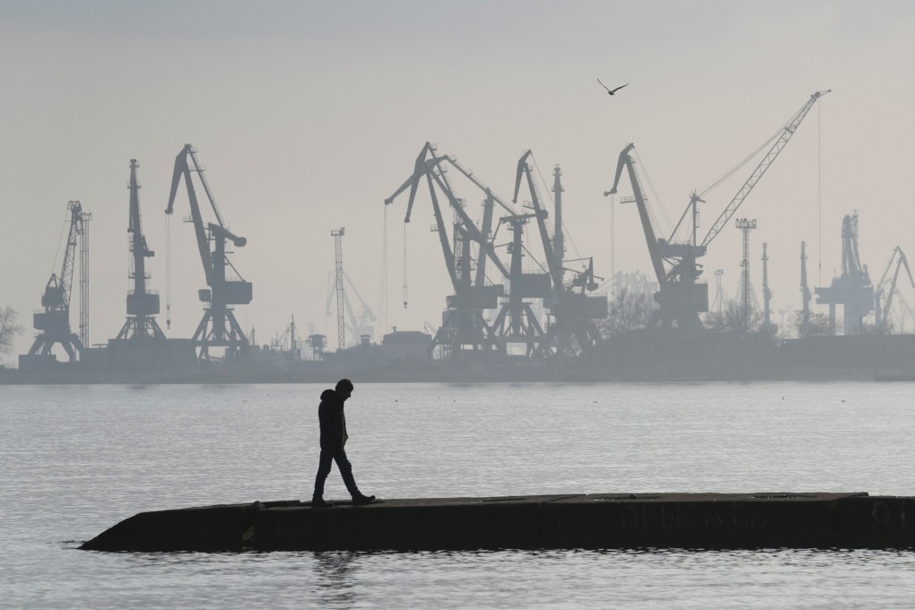 A man walks with harbour cranes in the background, at the trade port in Mariupol, Ukraine on February 23. Photo: AP