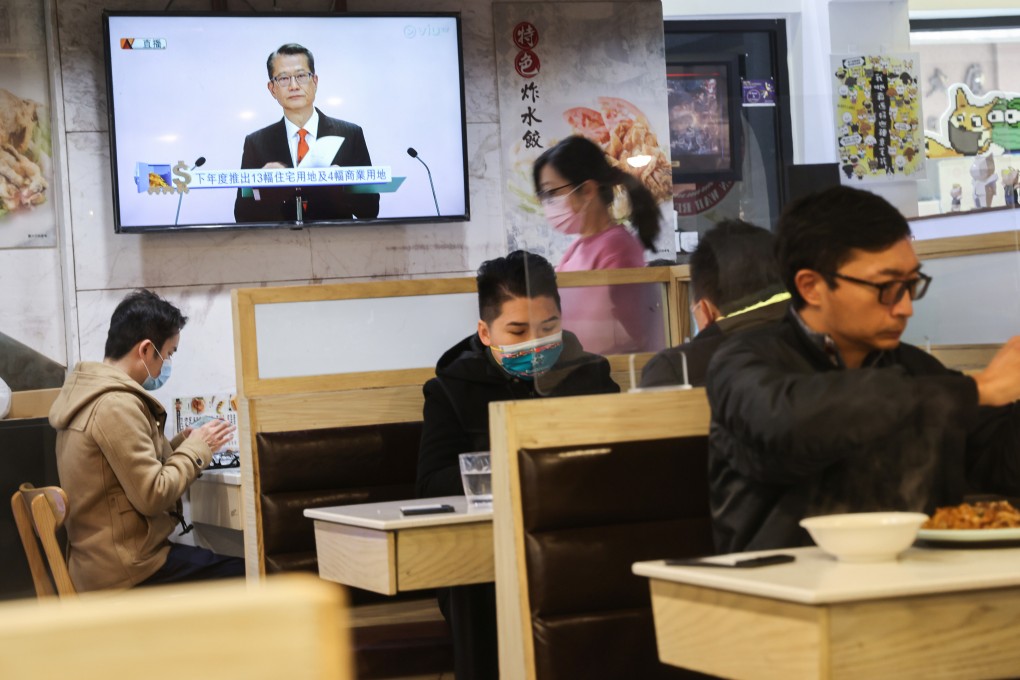 Financial Secretary Paul Chan is seen on a TV screen in a restaurant in Wan Chai delivering his budget on Wednesday. Photo: May Tse