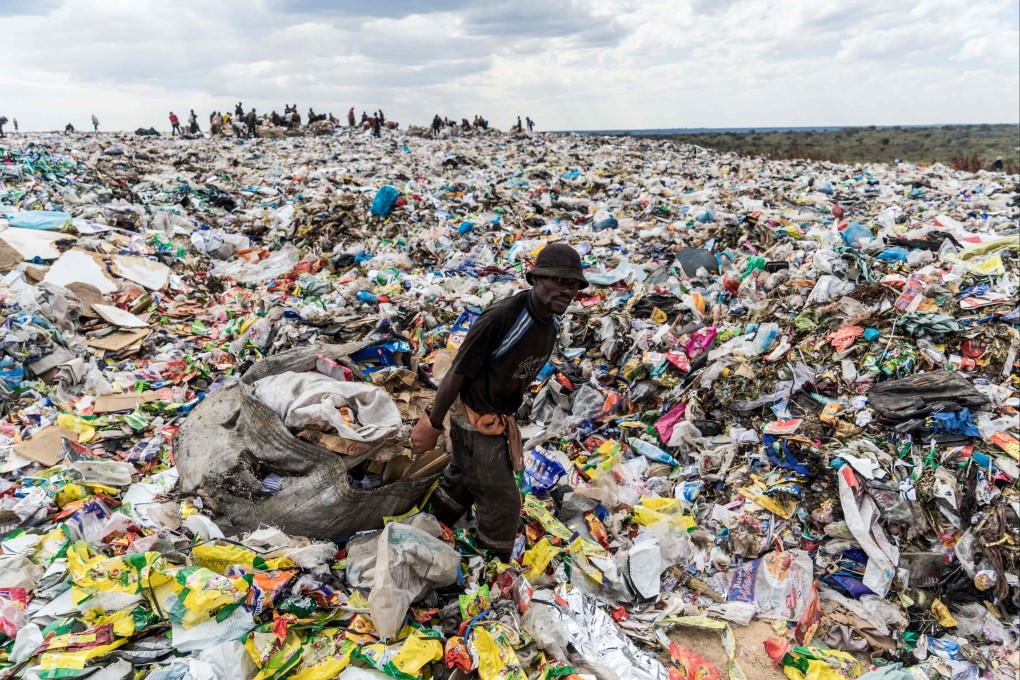 A recycler drags a heap of material from a dump in Bulawayo. Photo: AFP