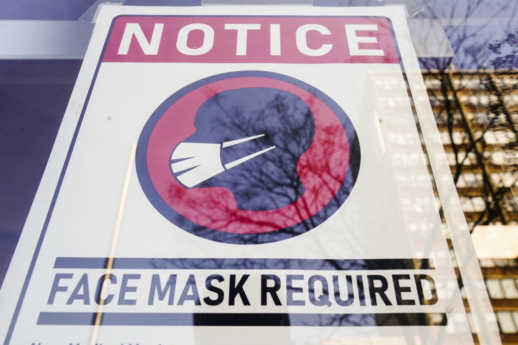 A sign requiring masks as a precaution against the spread of the coronavirus is posted on a store front in Philadelphia on February 16. Photo: AP