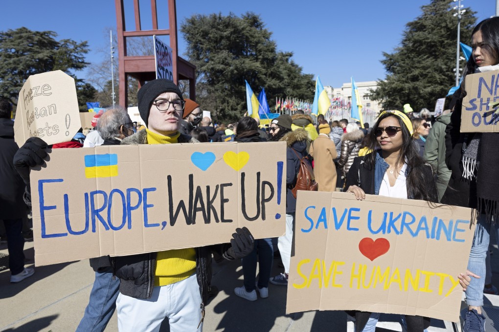 Demonstrators hold placards that reads “Europe, Wake Up!” and “Save Ukraine Save Humanity” during a rally in Geneva, Switzerland on  February 26. Photo: EPA-EFE