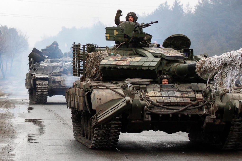 Ukrainian military personnel ride on tanks headed toward the front line against Russian forces in the Luhansk region of Ukraine on February 25, 2022. Photo: TNS