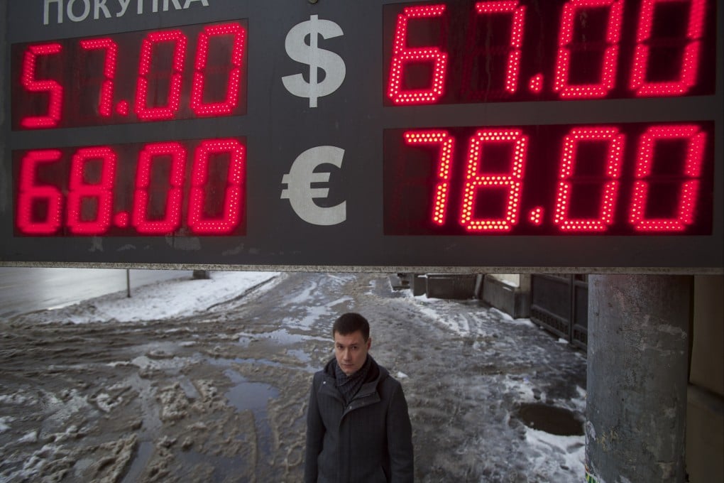 A man walks past an exchange office on a snowy Moscow street in Russia on January 12, 2015. Photo: AP