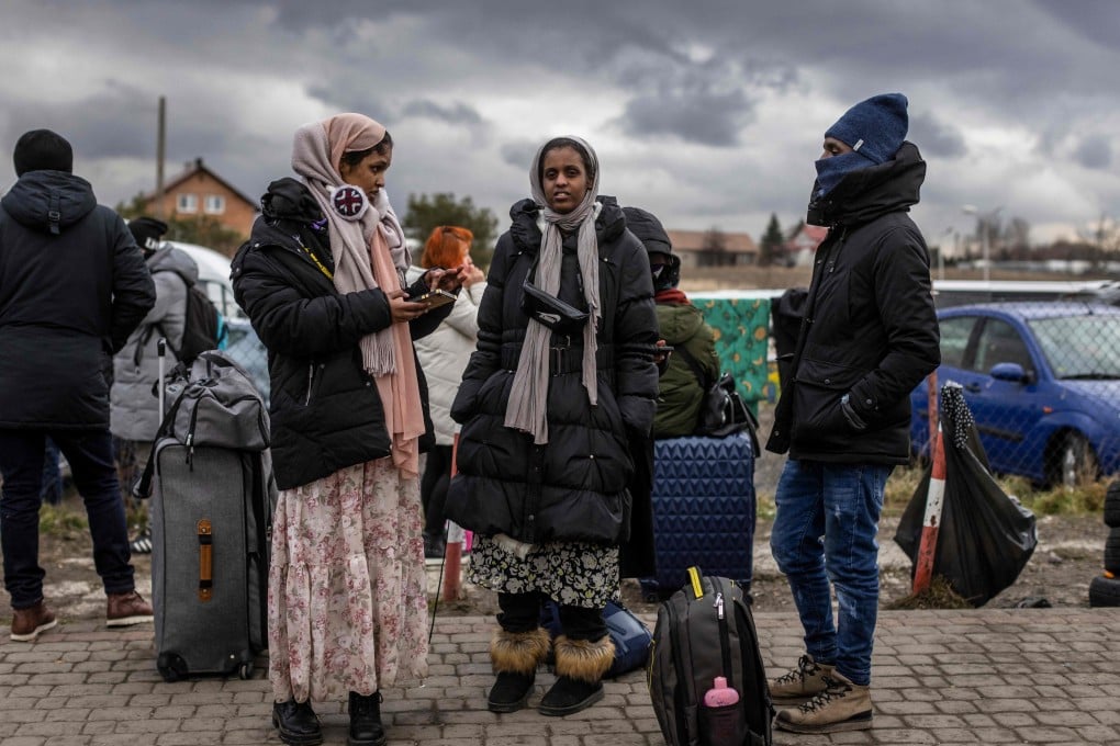 Indian girls wait for transport as refugees from many different countries, mostly students of Ukrainian universities arrive at the Medyka pedestrian border crossing fleeing the conflict in Ukraine, in eastern Poland on February 27, 2022. - Photo: AP