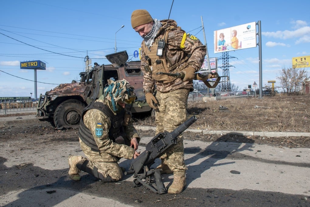 Ukrainian soldiers handle equipment from a damaged military vehicle after fighting in Kharkiv on Sunday. Photo: AP