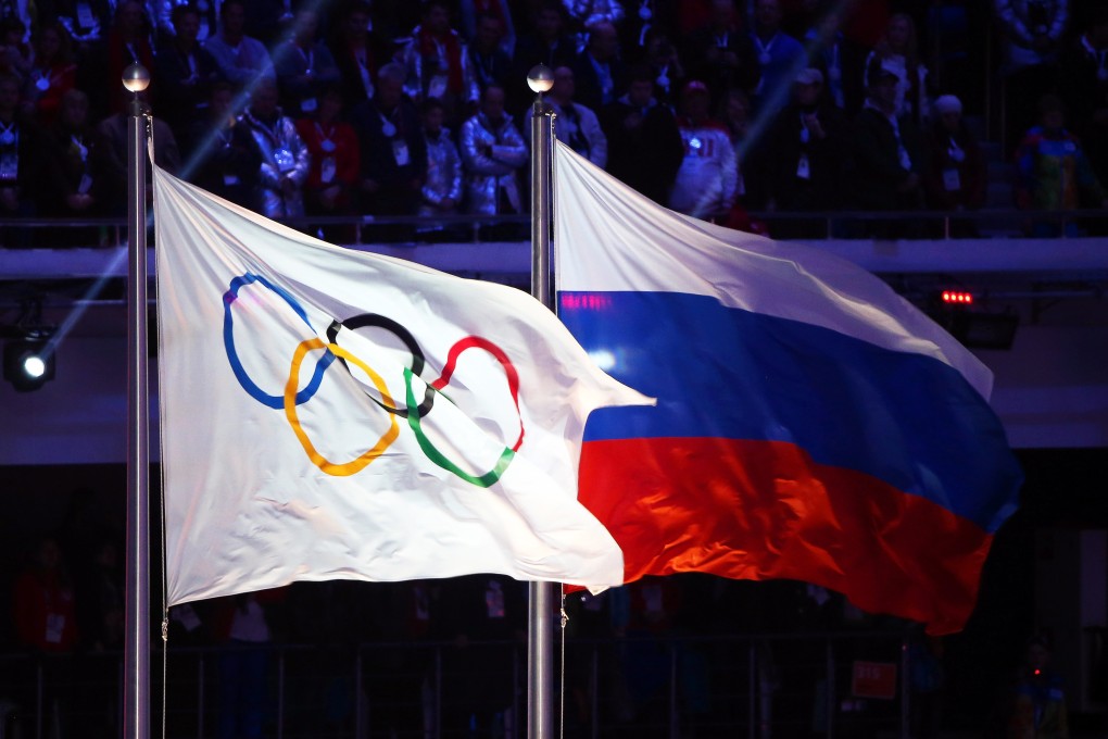 The Olympic flag (left) and Russian flag on display during the closing ceremony of the Sochi 2014 Olympic Games. Photo: EPA-EFE