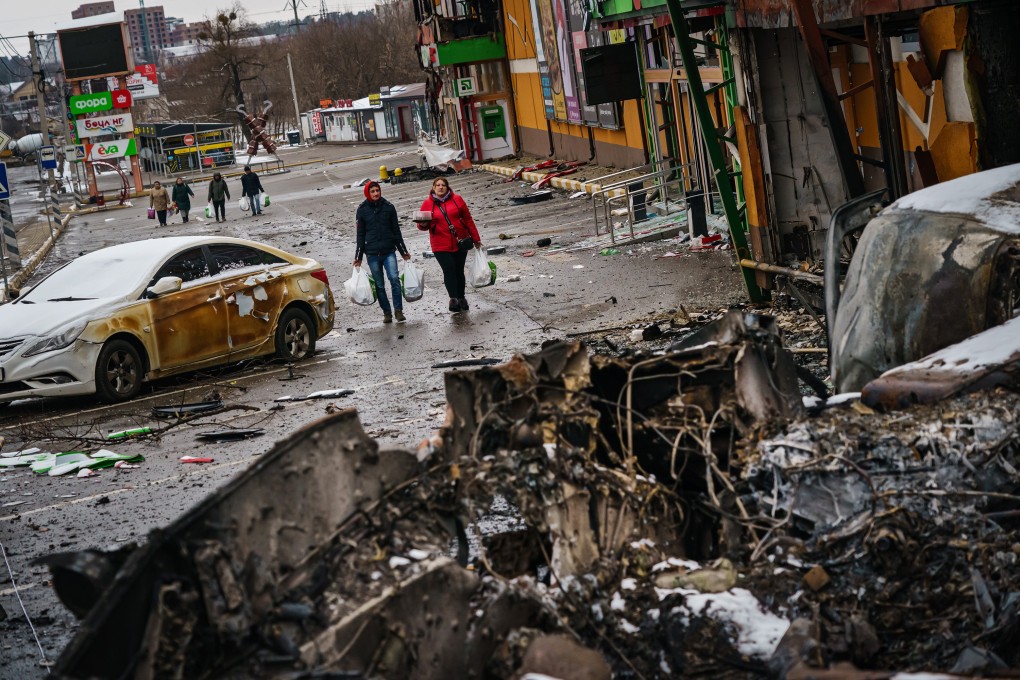 Residents walk back with supplies amid the debris of battle with Russian forces, on the outskirts of Irpin, Ukraine. Photo: TNS