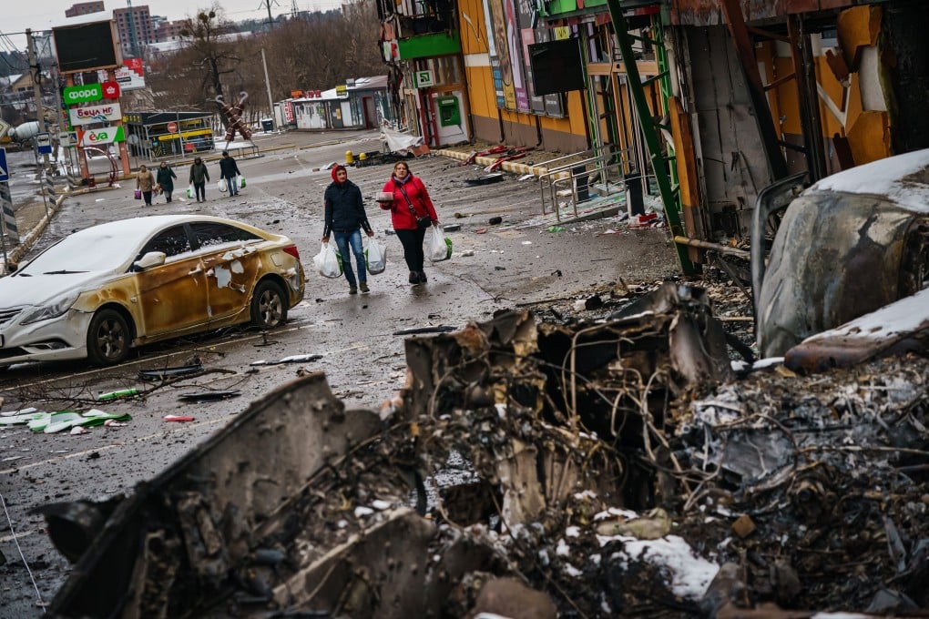 Residents walk back with supplies amid the debris of battle with Russian forces, on the outskirts of Irpin, Ukraine. Photo: TNS