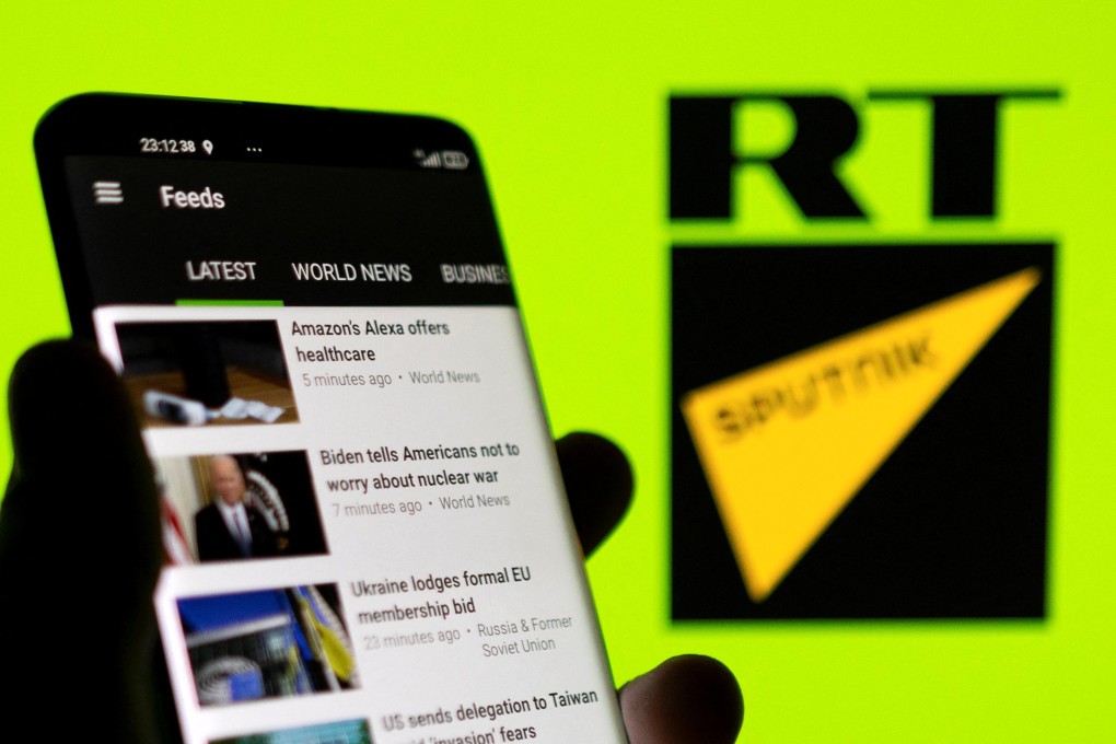 The RT app seen on a smartphone in front of the RT and Sputnik logos in this illustration taken February 28, 2022. Photo: Reuters