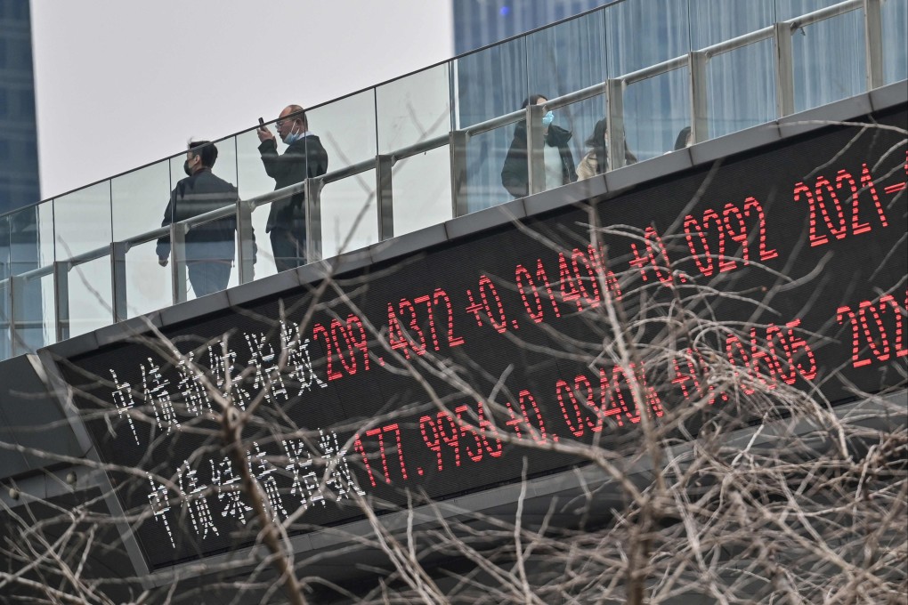 People walk across a bridge with a ticker board showing stock prices in Shanghai on February 22. Photo: AFP