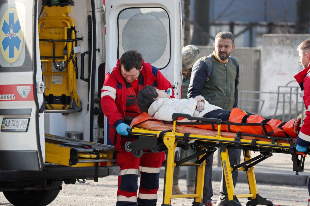 Medics transport a woman, wounded in the shelling of an apartment building, to an ambulance, as her husband stands nearby, in Kyiv, Ukraine. Photo: Reuters