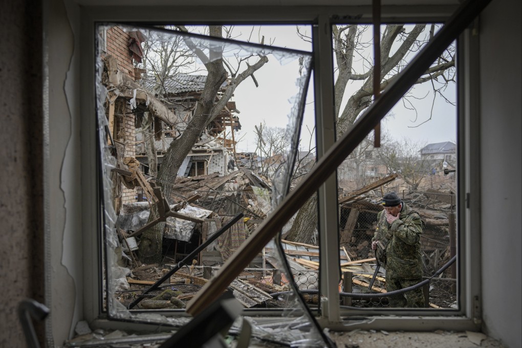 Andrey Goncharuk, 68, a member of territorial defense wipes his face in the backyard of a house that was damaged by a Russian airstrike, according to locals, in Gorenka. Photo: AP
