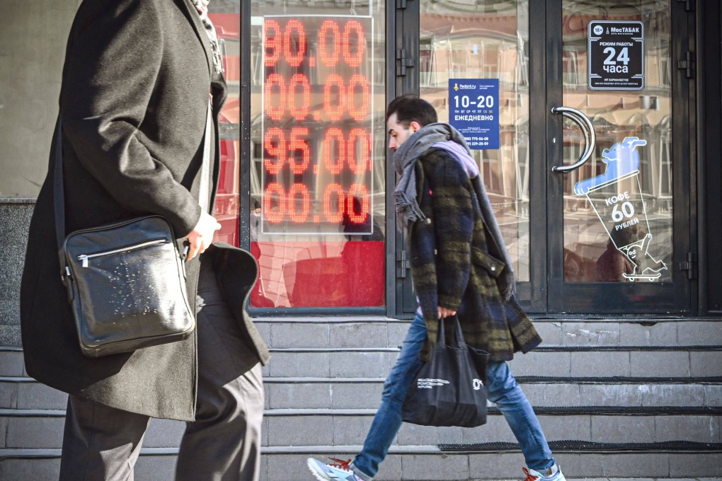 People walk past a currency exchange office in central Moscow on February 28. Photo: AFP