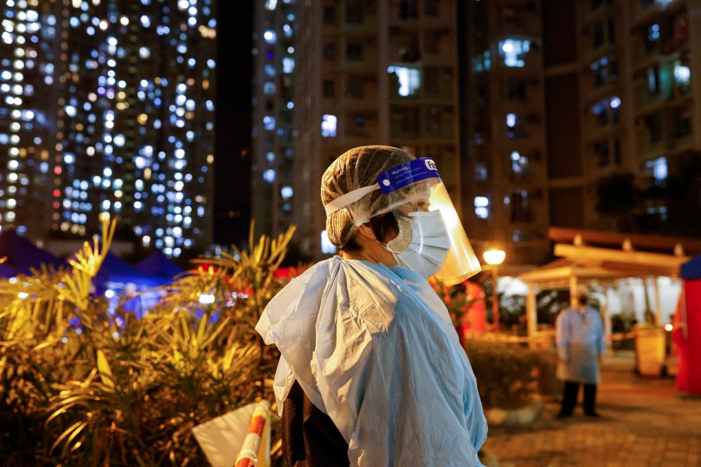 A woman wearing personal protective equipment waits outside a makeshift testing centre at a residential area under temporary lockdown on March 1. Photo: Tyrone Siu