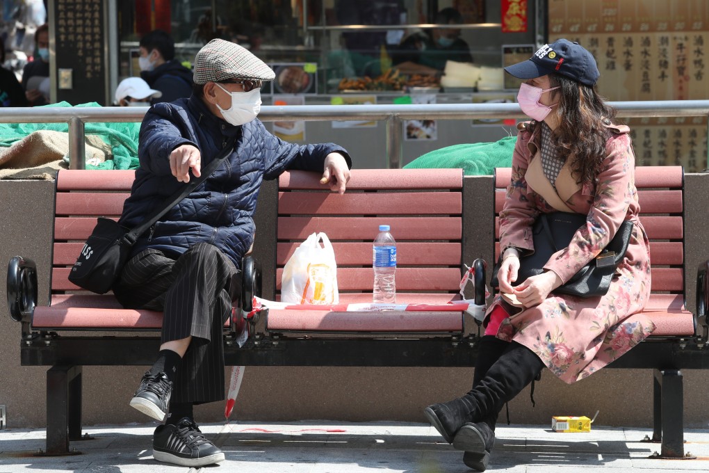 People chat on taped-off bench at a park in Prince Edward amid the fifth Covid-19 wave on February 25. Photo: Edmond So