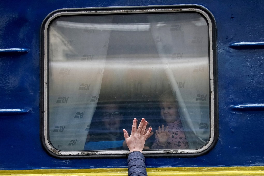 Ukrainian children look out from an evacuation train from Kyiv to Lviv as they say goodbye to their father on Thursday. Photo: Reuters