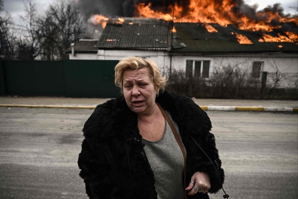 A woman turns from a burning house burning that was shelled in the city of Irpin, outside Kyiv, on Friday March 4, 2022. Photo: AFP