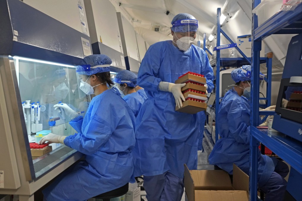 Health workers from mainland China test samples from Hong Kong residents for the coronavirus at an inflatable mobile testing lab in Hong Kong on March 1. Hong Kong has ramped up its testing capacity with the help of the mobile laboratories, as the city grapples with tens of thousands of Covid-19 cases daily. Photo: AP