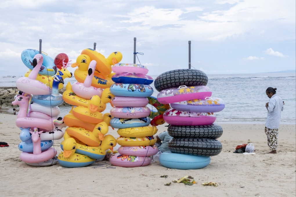 Vendor selling and renting inflatable beach toys waits for customers at a tourist area in Sanur, Bali, Indonesia. Photo: EPA-EFE